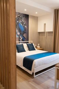 图里Antonio Busco rooms的一间卧室配有一张带蓝色枕头的大床