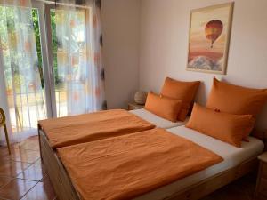 KirchdorfAtempause的一间卧室配有一张带橙色毯子的大床