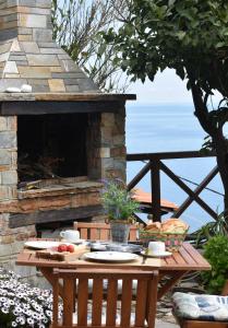 阿吉奥斯伊欧尼斯Thalatta Beyond Guesthouse Agios Ioannis的一张桌子,上面放着食物,旁边是石头壁炉