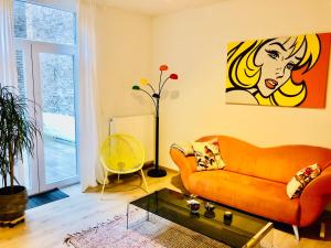 列日Lyves Two的客厅配有橙色沙发和绘画