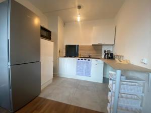 克莱蒙费朗Appartement, parking gratuit, sortie, autoroute, la méridienne的厨房配有白色橱柜和冰箱。