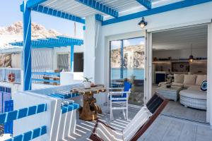 FiropótamosAquanis Anchored, sea front house, Firopotamos的蓝色和白色的房子,配有桌子和椅子