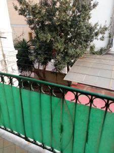 那不勒斯Flegrei Apartment的绿栏杆在树上的阳台