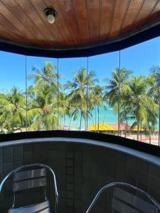 马塞约Edifício Casa Mar的浴室窗户享有棕榈树的景致。