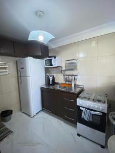 马塞约Edifício Casa Mar的厨房配有白色冰箱和炉灶。