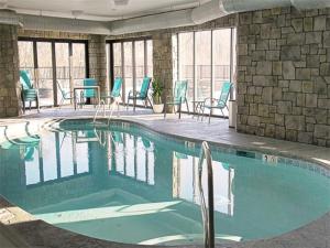 核桃溪The Wallhouse Hotel, Ascend Hotel Collection的大楼内带蓝色桌椅的游泳池