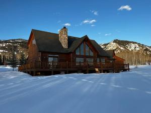 ThayneMAJESTIC VIEWS FAMILY LODGE with Large Deck的一座大木屋,位于雪中,与群山交织