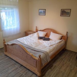 HegyhátszentmártonŐrségi Kistücsök Vendégház的一间卧室配有一张带两个枕头的木床