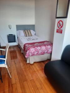 拉科鲁尼亚Hospedaje Lopez的卧室配有1张床、1张桌子和1把椅子