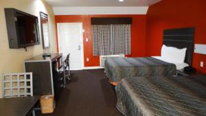 休斯顿Motel 6 Houston, TX – Willowbrook Mall的酒店客房带两张床和橙色墙壁