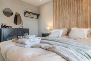 诺德克豪特Luxe appartement dichtbij strand en zee, in het hart van de bollenstreek的一间卧室配有两张带毛巾的床