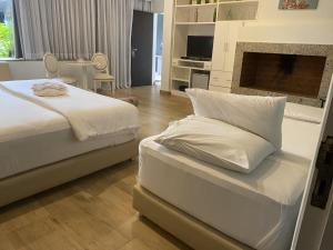 恩卡纳西翁Milord Hotel的一间卧室设有两张床和一个壁炉