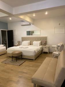 恩卡纳西翁Milord Hotel的卧室配有一张白色的大床和一张沙发。