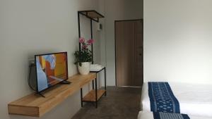 乌隆他尼Hug Udon Hotel的木桌旁配有电视的房间