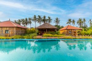 暹粒Authentic Khmer Village Resort的一个带游泳池和棕榈树的度假村