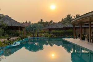 暹粒Authentic Khmer Village Resort的日落时分在度假村的游泳池
