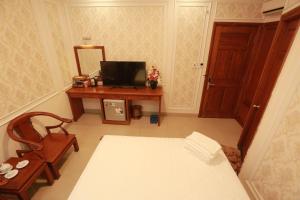 胡志明市THANH TAI HOTEl 1的客房设有一张床和一张带镜子的书桌