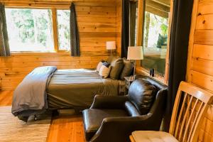 Shelter CoveCove Cabin Retreat的一间卧室配有一张床和一张皮椅