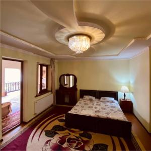 撒马尔罕Hotel Rahmon的一间卧室配有一张床,天花板配有吊灯