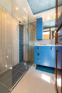 KapótidhesAlkis House by AegianKazarte的浴室设有蓝色橱柜和玻璃淋浴间。