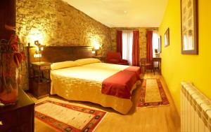 阿维莱斯敦佩德罗酒店的一间卧室设有一张床和石墙