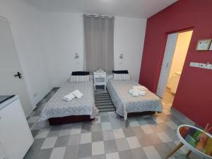 拉纳卡Magdalene's City House Inn的一间设有两张床和红色墙壁的客房