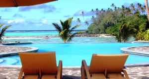 拉罗汤加诺特勒斯度假酒店的一个带两把椅子的游泳池和一个海滩