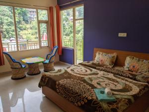 达兰萨拉Golden View B&B的卧室配有床、桌子和窗户。
