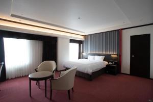 神户神户西神东方酒店的酒店客房带一张床、一张桌子和椅子