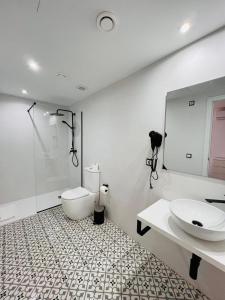 埃斯卡纳Jacaranda Apartments & Studios的一间带卫生间、水槽和镜子的浴室