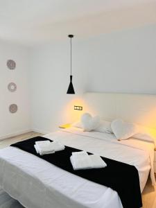 埃斯卡纳Jacaranda Apartments & Studios的一张白色的大床,带两条毛巾