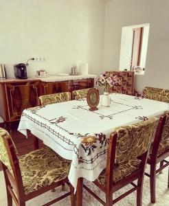 HăţăgelCountry House Hățăgel的餐桌、白色桌布和椅子