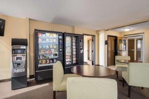 波特兰Rodeway Inn & Suites Portland - Jantzen Beach的一间带冰箱和桌椅的餐厅