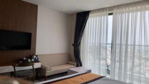 莲三Apec Tuy Hoà Phú Yên的酒店客房设有床、沙发和窗户。