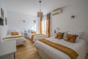 耶尔蒙蒂特拉内酒店的配有白色墙壁和木地板的客房内的两张床