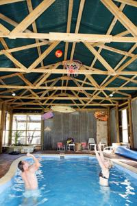 勒弗戴尔Lovedale Cottages Hunter Valley的两人在带篮球架的游泳池里