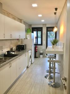 布拉加Alojamento Amélie - Apartamento的厨房配有白色橱柜和桌椅