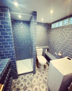 马赛Vaste loft plein de charme au cœur de Marseille的蓝色瓷砖浴室设有卫生间和水槽