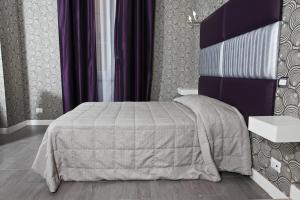 罗马那蒂兹美洲酒店的一间卧室配有一张床和紫色的墙壁