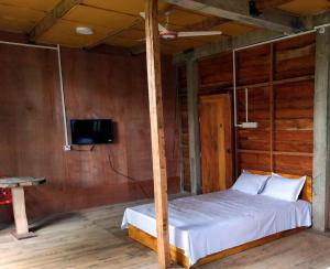 斯里曼加尔乌帕齐拉Jungle cottage的一间卧室配有一张床,墙上配有电视