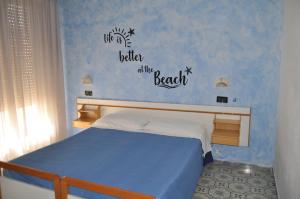 里乔内里戈贝罗酒店的卧室里配有一张床,海滩上的生活更好