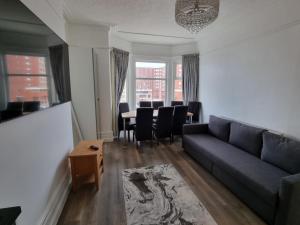 布莱克浦Granada Apartments Derby Road的客厅配有沙发和桌椅