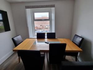 布莱克浦Granada Apartments Derby Road的餐桌、椅子和大窗户