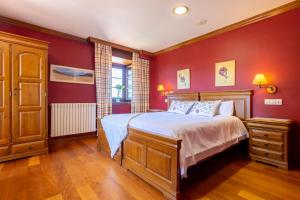 苏安塞斯波萨达蓬特波洛塔酒店的卧室设有红色的墙壁和一张带白色床单的床