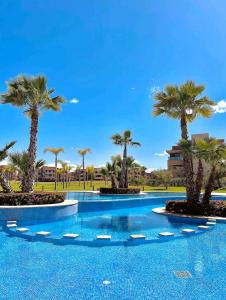 马拉喀什Marrakech golf city prestigia的度假村内棕榈树游泳池