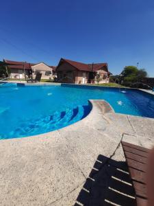康考迪亚Cabañas de Ayui的一座大型蓝色游泳池,后面有一座房子