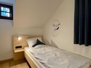 PentlingChalet an der Donau direkt bei Regensburg, 5 Sterne DTV的一间小卧室,配有白色的床和窗户