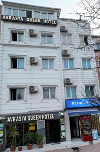 伊斯坦布尔AVRASYAQUEEN HOTEL的白色的建筑,上面有标志