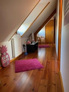 圣加蒂安代布瓦Gîte Pressoir Armand的客厅铺有木地板,配有粉红色地毯。