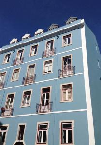 里斯本New Art Apartment的蓝色的建筑,设有窗户和阳台